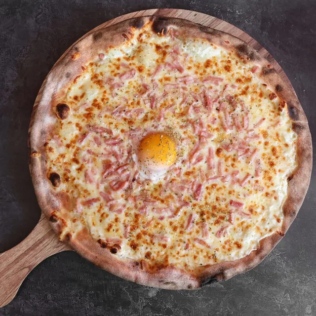 Pizza de un cliente recién salida del horno de leña