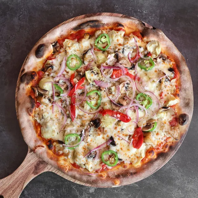 Pizza de un cliente recién salida del horno de leña