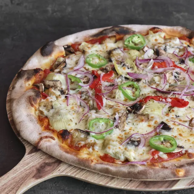 Pizza de un cliente recién salida del horno de leña