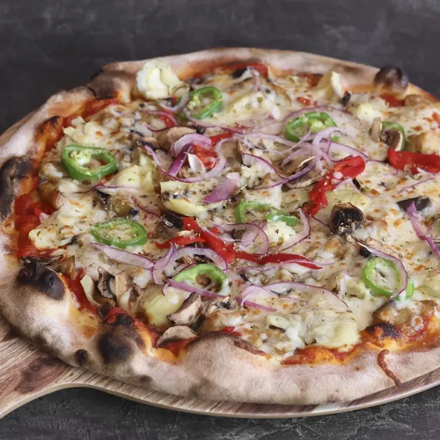 Pizza de un cliente recién salida del horno de leña