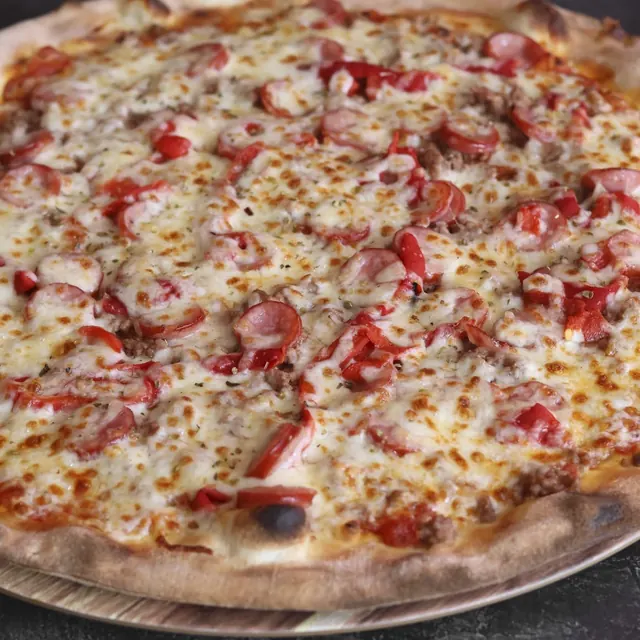 Pizza de un cliente recién salida del horno de leña