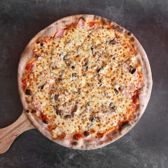 Pizza de un cliente recién salida del horno de leña