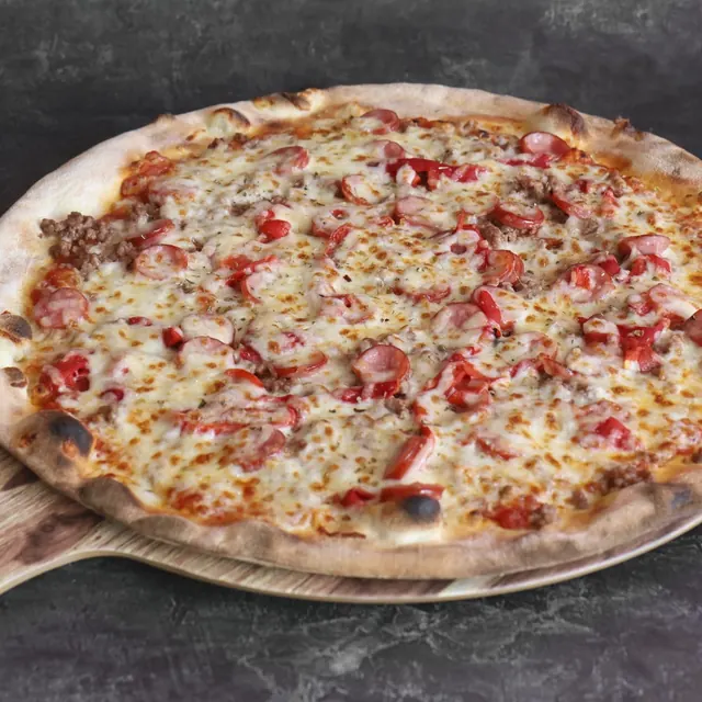 Pizza de un cliente recién salida del horno de leña