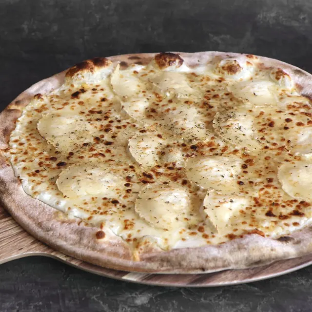 Pizza de un cliente recién salida del horno de leña