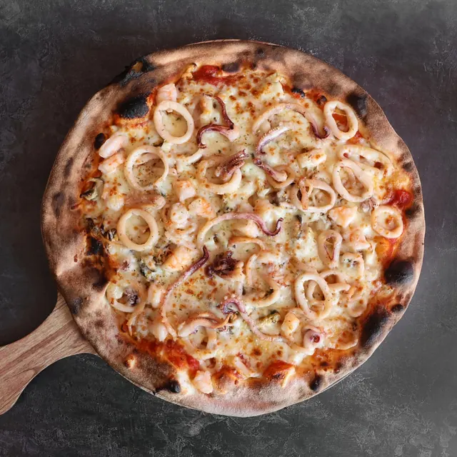 Pizza de un cliente recién salida del horno de leña
