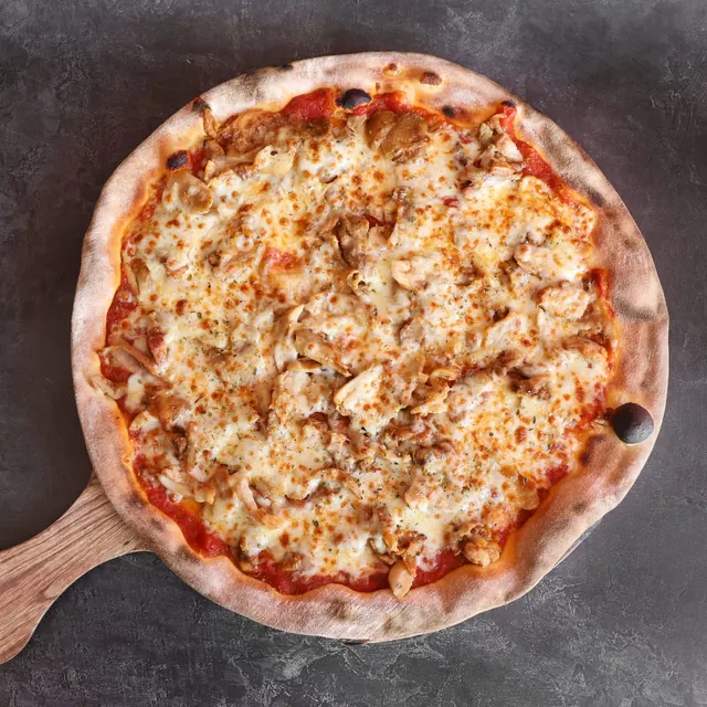 Pizza de un cliente recién salida del horno de leña